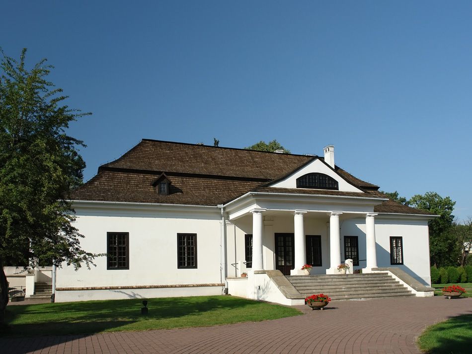 Dom w stylu dworkowym z jasną elewacją